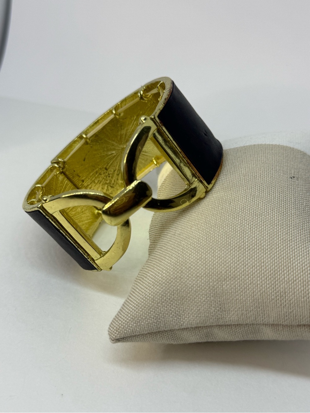 Black faux leather elastic bracelet with a gold-tone finish.